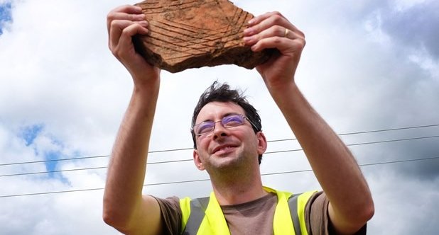 Man In Hi-Vis Holding Ancient Ceramic