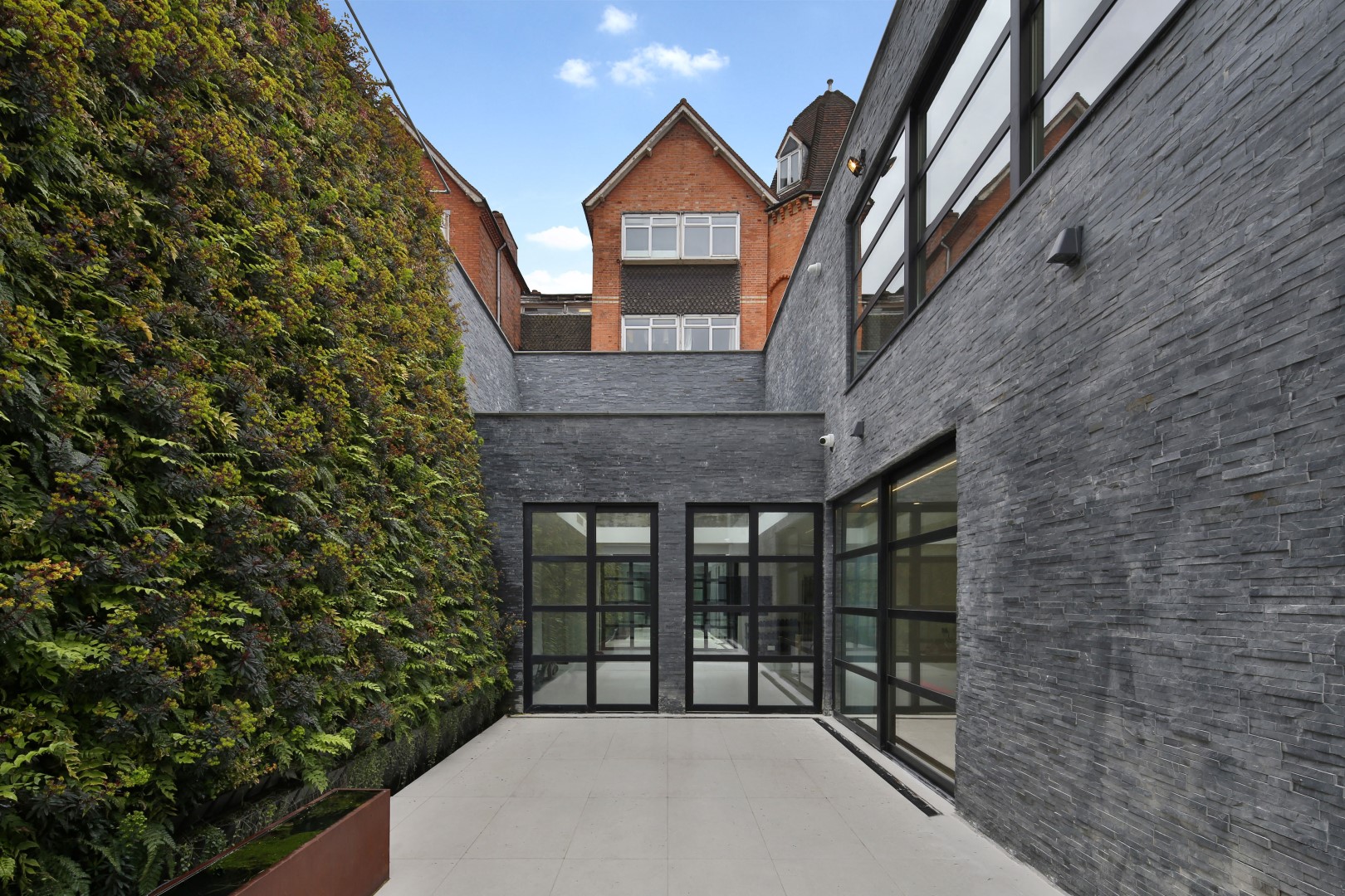sunken house back view glass windows grey stone walls