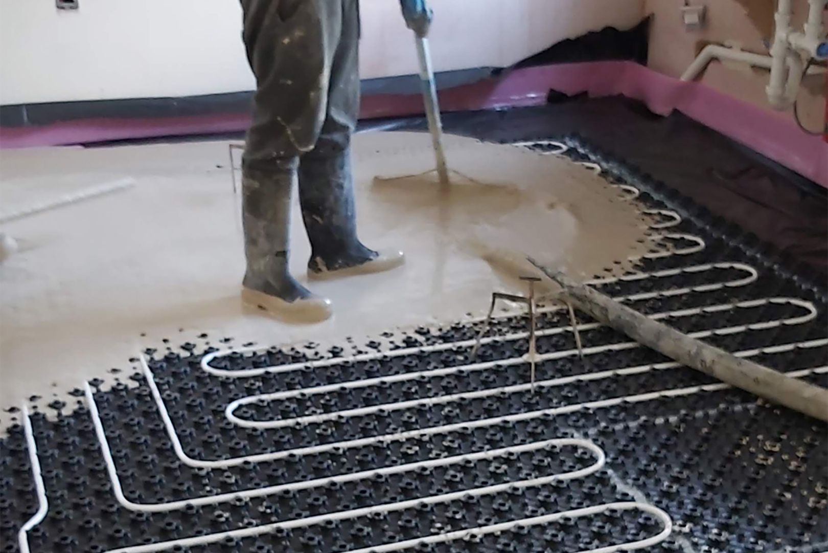 Man Laying Screed Over Underfloor Heating