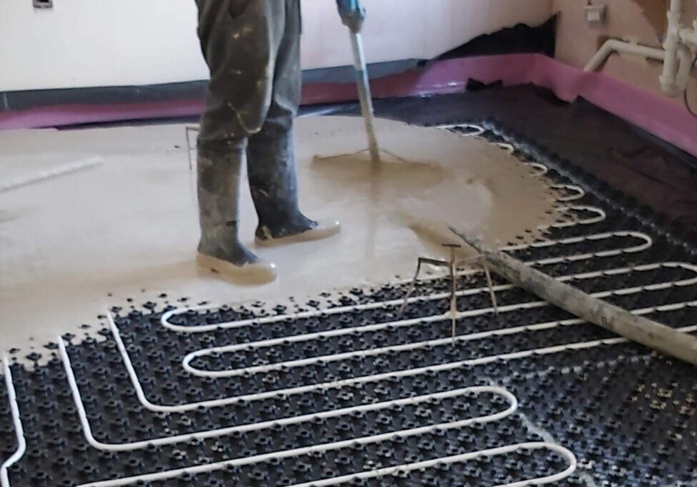 Man Laying Screed Over Underfloor Heating