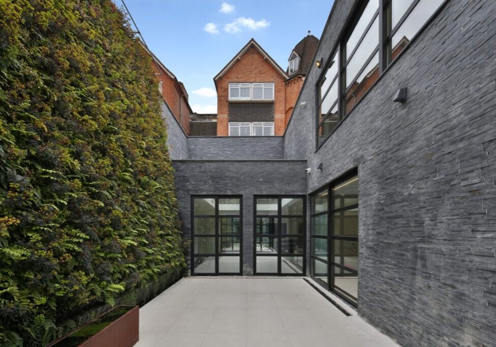sunken house back view glass windows grey stone walls