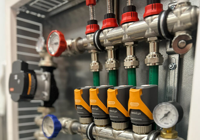 Ambiente UFH stainless steel manifold with CircoMax 3 pumpset, AmbiEgo actuators, TraffiPipe T16 UFH pipe, flow meters and temperature gauge ball valves installed